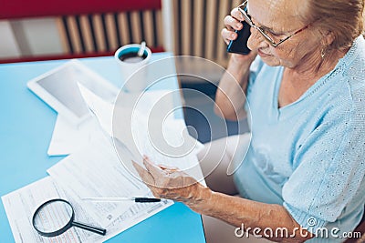 Elderly woman contacting custumer services after recieving a bill Stock Photo