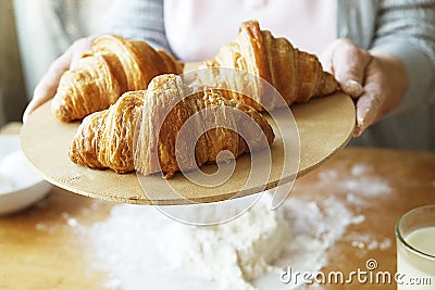 Elderly woman cooks french croissants, bare wrinkled hands, ingredients, soft warm morning light,top view Stock Photo