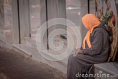 An Elderly woman with covered head sitting Editorial Stock Photo