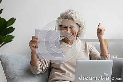 Elderly woman feels overjoyed reading great news in letter Stock Photo