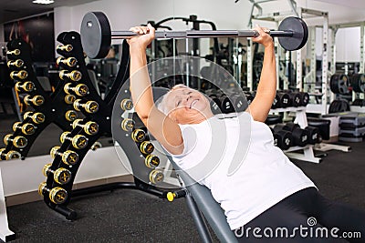elderly woman with gray hair plays sports in gym. Active healthy lifestyle, pensioner, senior concept. Rehabilitation Stock Photo