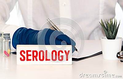 Elderly woman holds wooden cubes in her hands with the inscription SEROLOGY Stock Photo