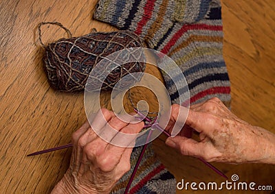 Elderly Woman Knitting Socks Stock Photo