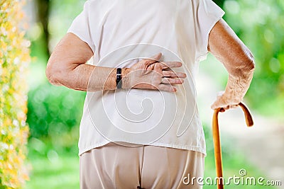 Elderly woman outdoors with back pain Stock Photo