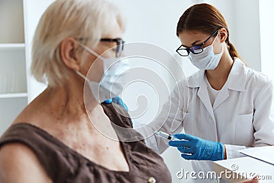 elderly woman patient next to the doctor vaccine passport Stock Photo