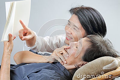 Elderly woman reading fable book with daughter Stock Photo