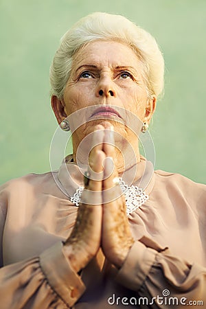 Portrait of serious old caucasian woman praying god Stock Photo