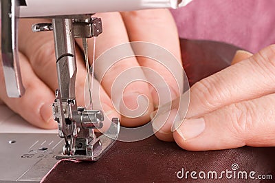 Elderly woman sews on the sewing machine Stock Photo