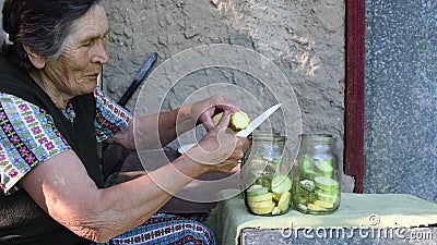 Elderly woman slice squash and put into jar Stock Photo