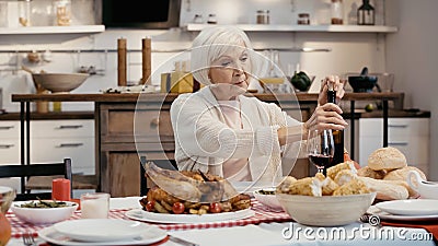 elderly woman uncorking bottle of red Stock Photo