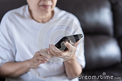 Elderly woman using her phone in home Stock Photo