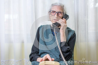 Elderly woman using the phone indoors Stock Photo