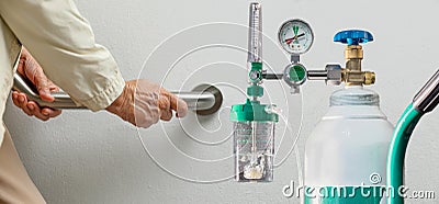 Elderly woman walking to emergency medical oxygen tank Stock Photo