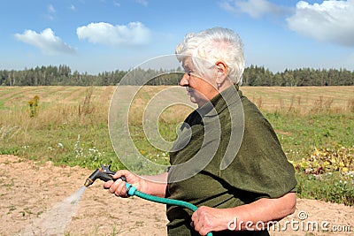 An elderly woman watering Stock Photo