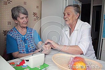 Elderly woman comforts her friend Editorial Stock Photo