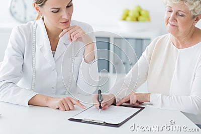 Elderly woman choosing diet plan Stock Photo