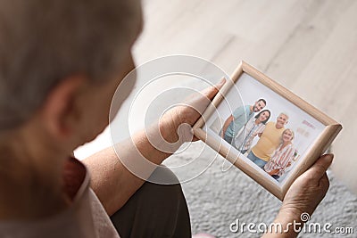 Elderly woman with framed family portrait Stock Photo