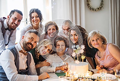 An elderly woman with multigeneration family celebrating birthday on indoor party. Stock Photo
