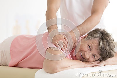 Masseur setting elderly woman shoulder Stock Photo