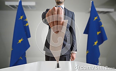 Election or referendum in European Union. Voter holds envelope in hand above ballot. EU flags in background Stock Photo