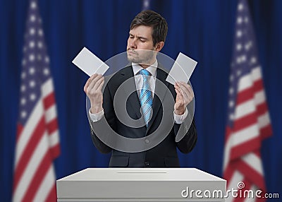 Election in United States of America. Undecided voter holds envelopes above vote ballot. Stock Photo