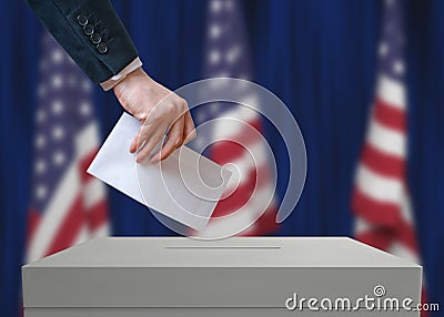 Election in United States of America. Voter holds envelope in hand above vote ballot. Stock Photo