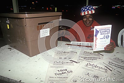 Election volunteer and ballot box in a polling place, CA Editorial Stock Photo