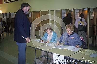 Election volunteers assisting voters in a polling place, CA Editorial Stock Photo