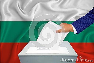 Elections in the country - voting at the ballot box. A man`s hand puts his vote into the ballot box. Flag Bulgaria on background Stock Photo