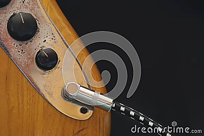 Electric bass guitar volume and tone knobs with quarter-inch jack cable connected to the output Stock Photo