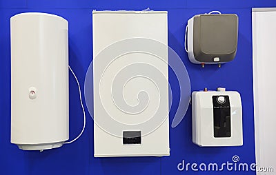 Electric boilers, water heaters display of different sizes and forms, hung on a wall in a shop for sale Stock Photo