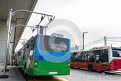 Electric bus at a stop is charged by pantograph. Clean mobility Stock Photo