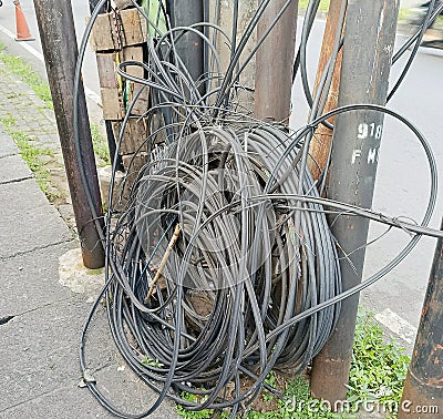 Electric cable reels on the side of the road can endanger pedestrians against the background of the road Stock Photo