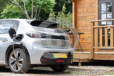 Electric car on charge at home green stripe on numberplate Stock Photo