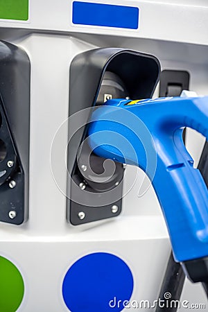The electric vehicle charging gun is inserted into the socket of the charging station column while waiting for the vehicle to be Stock Photo