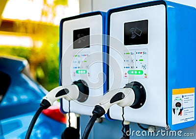 Electric car charging station. Plug for vehicle with electric motor. Coin-operated charging station. Clean energy power. Stock Photo