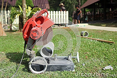 Electric circular saw cutting the cement pipe. Stock Photo