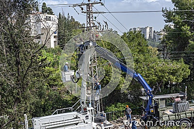 Electric company team working on a transmission tower using two truck lifts Editorial Stock Photo