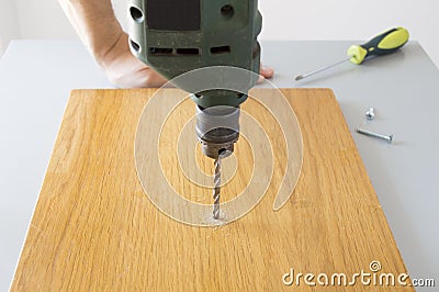 Electric drill drilling a hole Stock Photo
