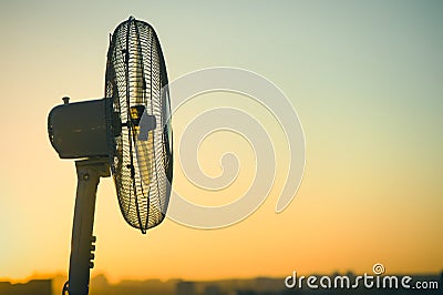 Electric fan ventilator against a background of a clear sunset sky. Concept Stock Photo