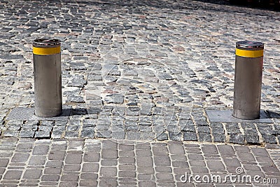 Electric gray hydraulic bollard with a yellow reflective stripe barrier. Stock Photo
