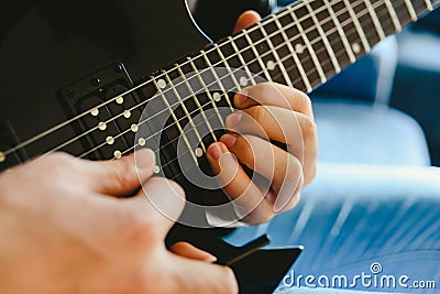 Electric guitar teacher teaching how to place fingers to play a chord Stock Photo
