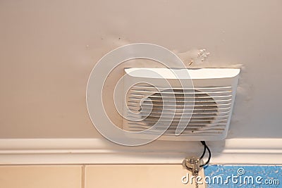 electric hood on the ceiling in the bathroom in the apartment, ventilation hole in the bathroom Stock Photo
