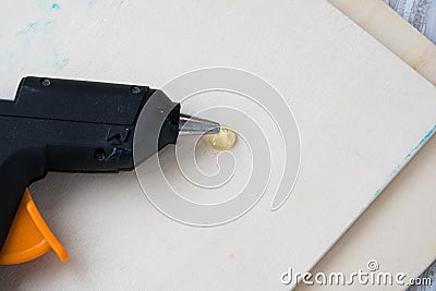 Electric hot glue gun on a wood background. the concept of repair or creativity background Stock Photo