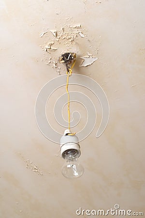 Electric lamp hanging from reapair ceiling Stock Photo