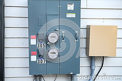 Electric Meters For Apartments are located on the wall outside the building. Close-up Editorial Stock Photo