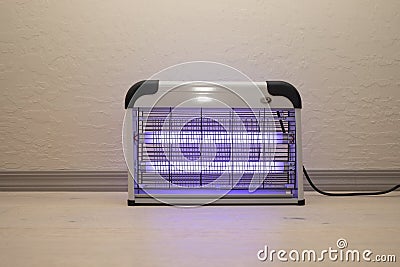 Electric Mosquito and Insect Zapper With Blue Purple Lights Turned on. Bug Killer Lamp on Stock Photo