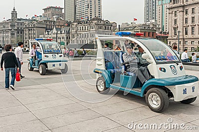 2 electric police vehicles on boardwalk along Bund, Shanghai, China Editorial Stock Photo