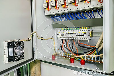 Electric power circuit breakers are in the fuse box. The wires with the terminals are grounded in the electrical cabinet. Modern Editorial Stock Photo