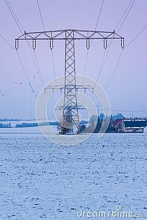 view of electric power lines with wind turbines in winter landscape, germany, thuringia Stock Photo